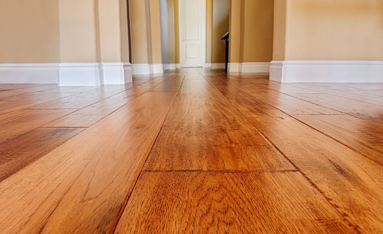 A well-finished hardwood floor with white trim in a home, representing flooring services in Chicago, IL.