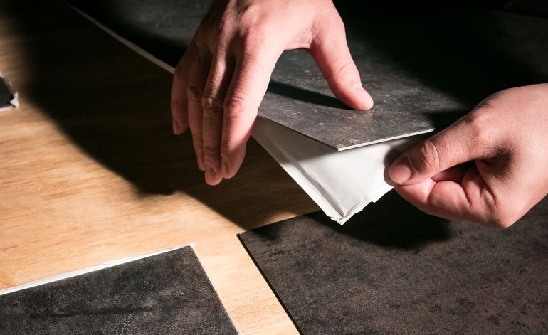A person cutting paper on a table, reflecting a workspace associated with luxury vinyl tile flooring services in Chicago, IL.